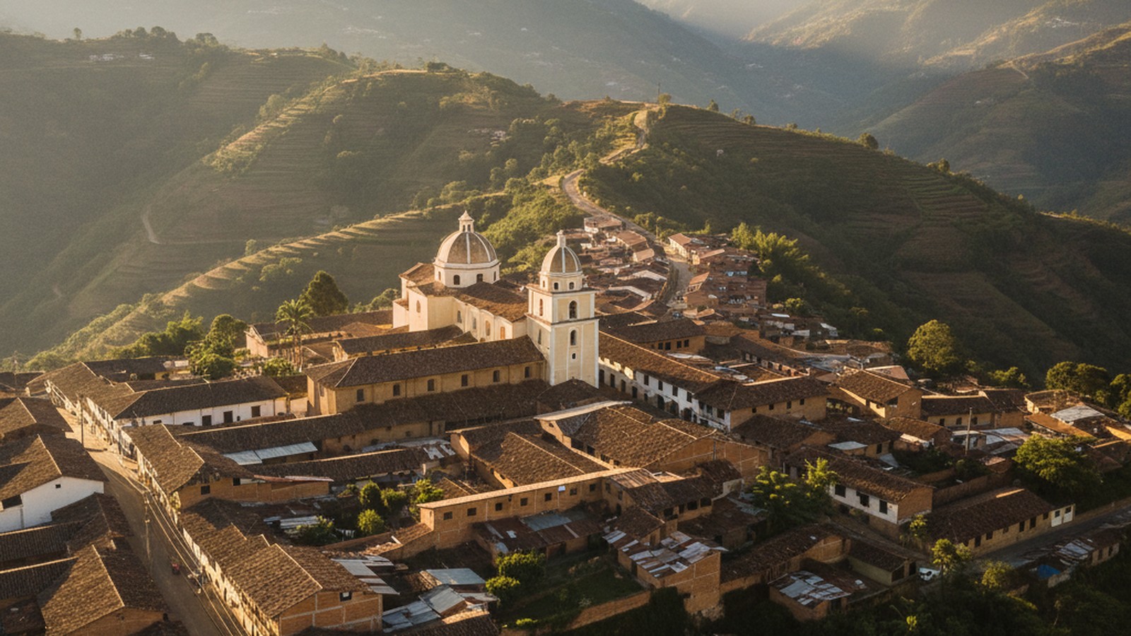 Vista aérea del pueblo de Yarumal en las montañas de Antioquia al amanecer, con la iglesia colonial y casas de tejado de barro, símbolo de la región donde una sola familia paisa enseñó al mundo la genética del Alzheimer.